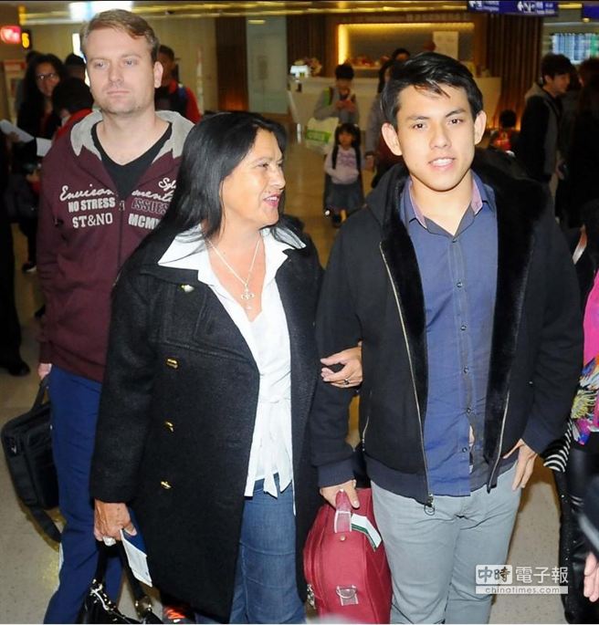 吴忆桦(右)在养母叶特纳(左)与义兄卡西欧(后)陪伴下搭机抵台。(高兴宇摄)