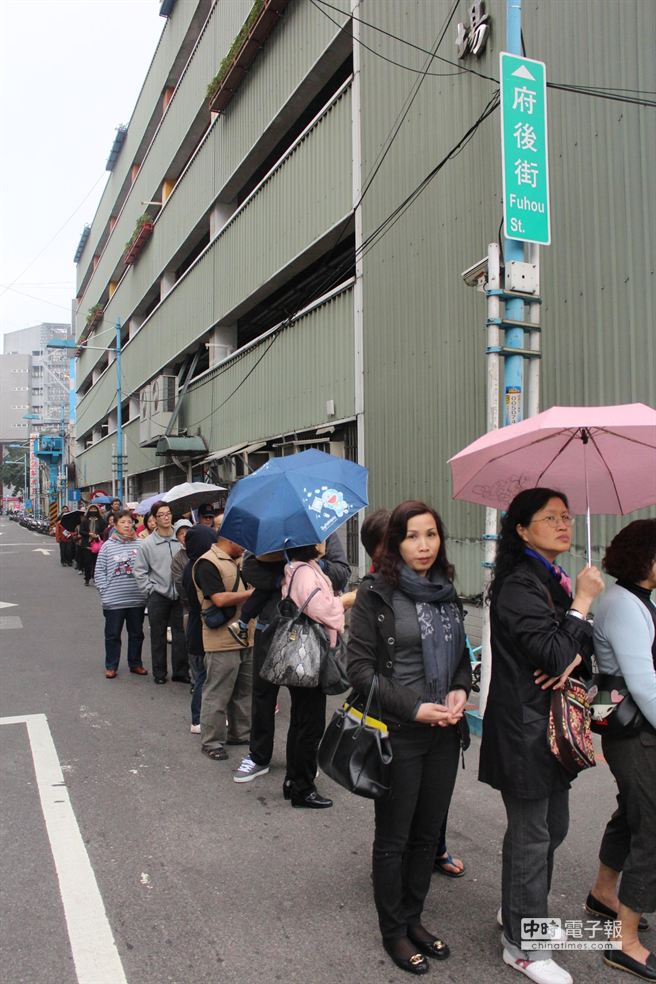 民眾不畏風雨，排隊領取發財金。（郭逸攝）