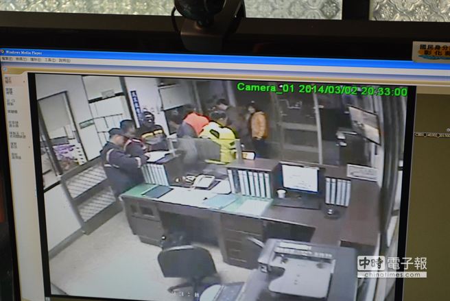 甘姓重機車支（黃衣者）在派出所與小貨車駕駛和解走到值班台時，突然倒地不起。（鐘武達翻攝）