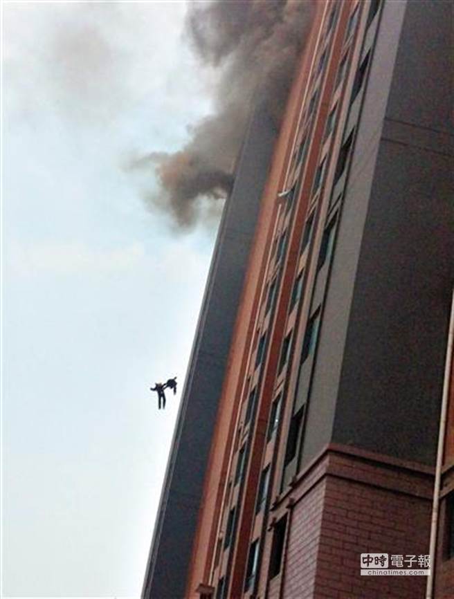 兩名消防隊員手握手墜樓瞬間。(鳳凰網)