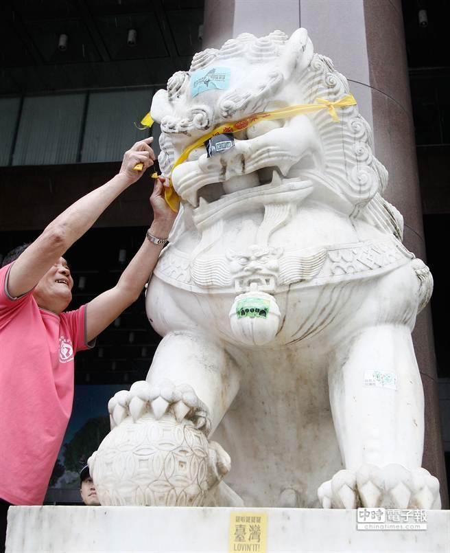 「反迫遷，護樂生！」青年樂生聯盟8日晚間夜宿在北市府前廣場，今(9)日一早市府清潔人員將大門口石獅上的貼紙與標語清除。（張鎧乙攝）