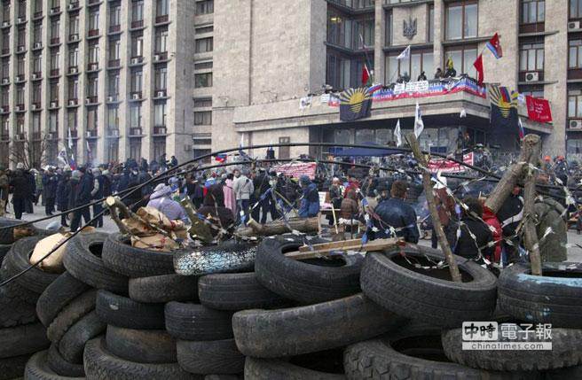 圖為烏克蘭東部頓內茨州親俄分子4月時堆疊障礙物，對抗警方。(美聯社)