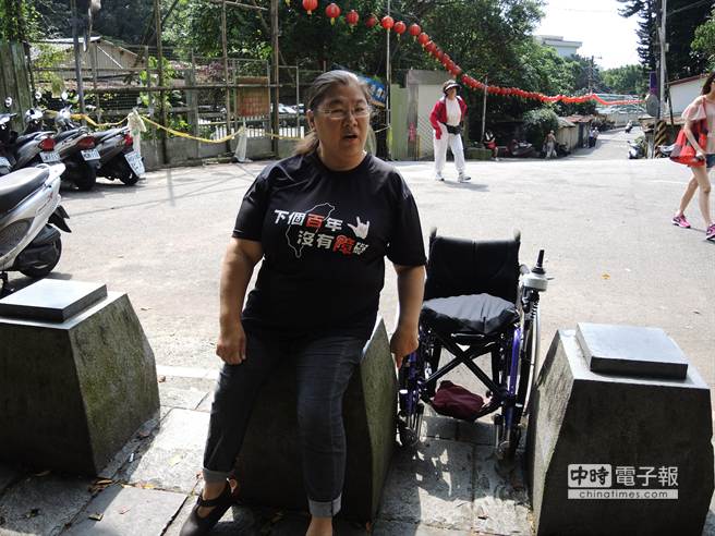 虎山溪步道入口處設有多個路阻，連小型電動輪椅都無法通過，身障者需起身坐在路阻上，由隨行者將輪椅折疊收起，才能進入步道。（張潼攝）