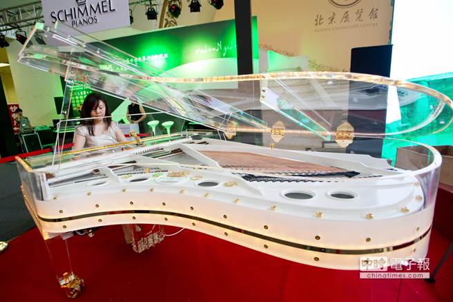 3. 7月4日，在第三屆北京國際頂級生活品牌（奢侈品）博覽會上，一名工作人員在彈奏德國舒密爾鋼琴展示的水晶鋼琴。新華社發