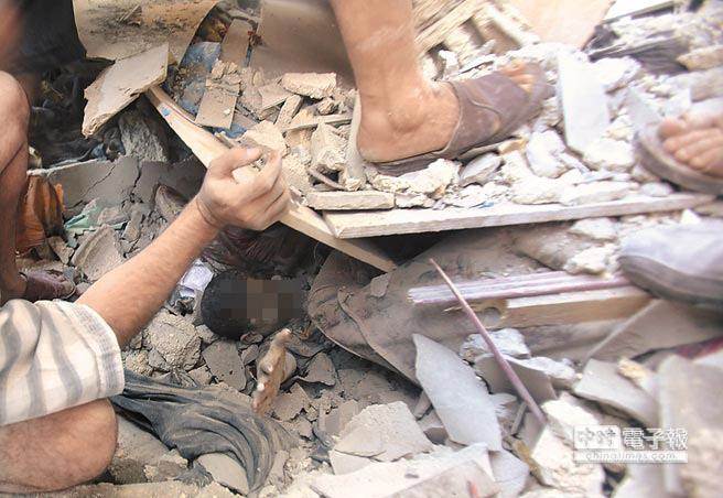 人命遭踐踏！以色列3日空襲迦薩走廊南部拉法地區，1名巴勒斯坦男童傷重且身陷瓦礫堆中動彈不得，眾人急於將他救出。（路透）