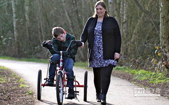 詹姆斯行動需要依靠輪椅，他的母親蘇珊娜陪他在戶外散步。(圖取自網路)