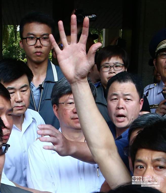 有民眾試圖丟擲物品，遭到警方伸手阻攔。（陳信翰攝）