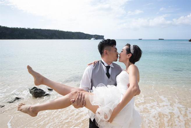 史丹利（左）、Gigi浪漫在沖繩完婚，海邊新娘抱擁吻，羨煞旁人。（圖／華德培婚禮）