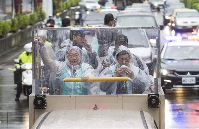 民进党提名立法委员候选人陈永福（左）与民进党副总统候选人陈建仁（右）雨天扫街，虽然前方有板子但仍需要一直擦脸。（陈仁萱摄）