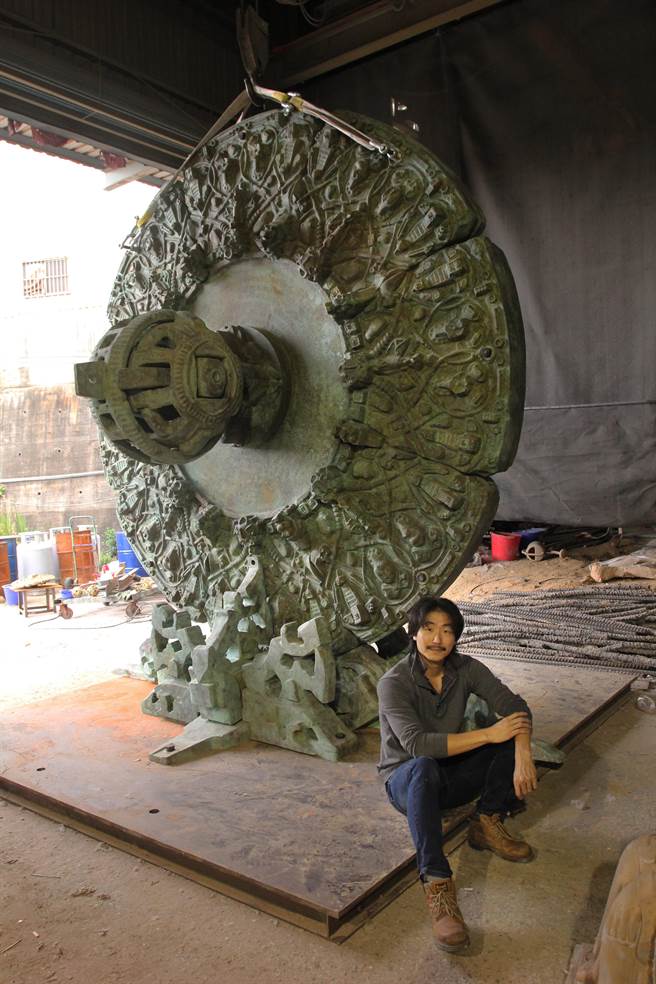 涂維政和3.5米高的銅雕《卜湳文明—魂遁之輪》合影。（耿畫廊提供）