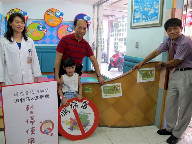 高雄市衛生局為防範腸病毒，今天起勸導各醫療院所關閉兒童遊戲設施，副局長林盟喬（右起）、新興區衛生所長鄭文聰及偉峰診所小兒專科醫師林黛侑示範示封閉兒童遊戲區。（呂素麗攝）