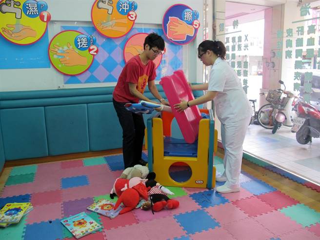 高雄市衛生局為防範腸病毒，今天起勸導各醫療院所關閉兒童遊戲設施，醫護人員收拾兒童遊戲設備。（呂素麗攝）
