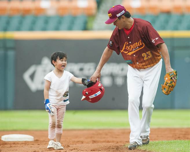 比赛结束后前统一球员许圣杰(右)，让女儿带着头盔到球场中，体验下棒球场的滋味。 (资料照，郑任南摄)