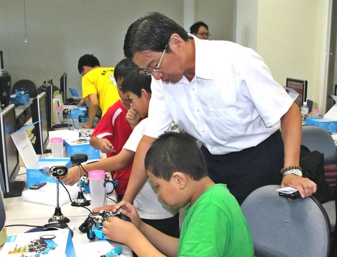 草屯公所开设的MBLOCK机器人夏令营，镇长洪国浩特地前往关怀小朋友，并了解学童兴趣盎然地组装机器人。（杨树煌摄）