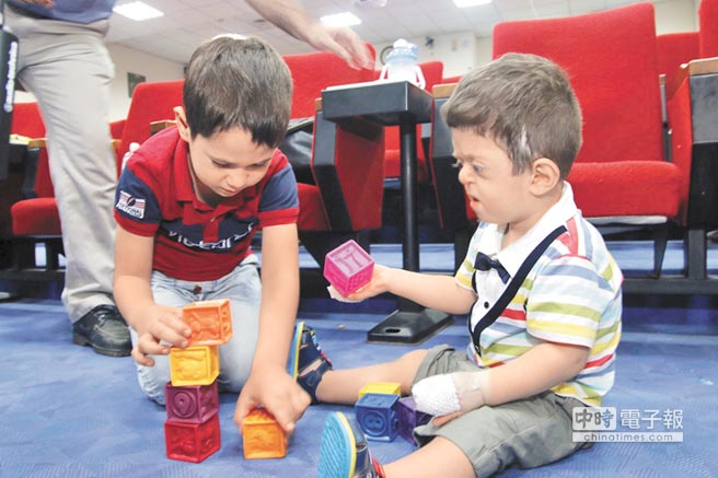 重生約旦籍巴勒斯坦裔2歲男童Eyas（右）歷經併指分離手術，終於能像同齡孩子一樣玩玩具。（徐養齡攝）