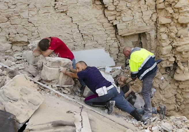 8月24日一名在Amatrice的男性在搜救人員搶救困在殘骸中的友人(右)時忍不住痛哭。(美聯社)
