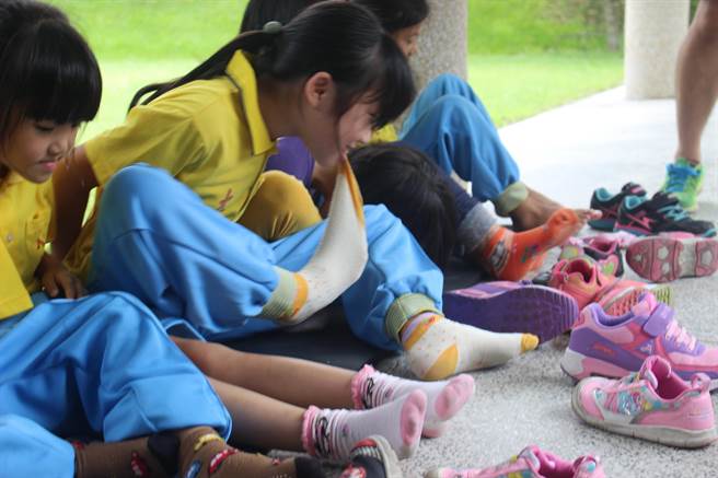 「不用手脫鞋襪好難喔！」學童想盡辦法使勁脫，有人乾脆直接用嘴巴來比較快。（陳淑娥攝）