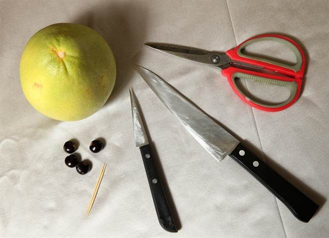簡單九步驟雕兔子之1.準備至少一把水果刀、一支剪刀、一根牙籤、一顆柚子與一顆龍眼核。（王英豪攝）