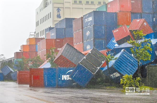 高雄金福路旁的货柜堆置场大型货柜不敌强风，被吹倒掉落地面。（王锦河摄）