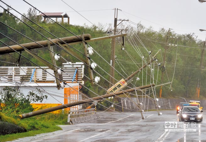 屏东一处高压电缆线不敌强风肆虐横倒在公路上。（法新社）