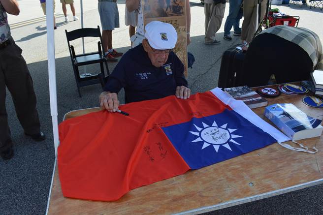 本年度战鹰周末上，科尔在中华民国空军代表团携去的国旗上签名。（许剑虹摄）