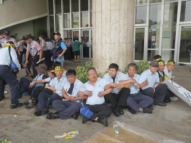衝破警力封鎖的台化員工手拉手在縣府大門外圍坐。（謝瓊雲攝）