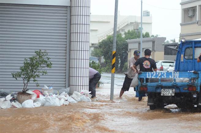民眾運來沙包堆門口，搶救家園。（黃力勉攝）