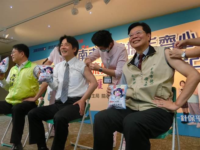 台南市長賴清德、衛生局長林聖哲挽衣袖施打疫苗，人手一包乖乖。(曹婷婷攝)