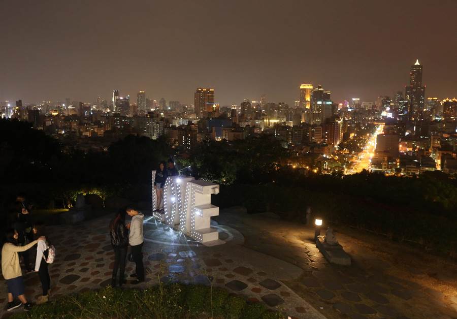 不少情侶14日情人節晚間在高雄壽山 LOVE 地標前拍照留念，共度情人節。（王錦河攝）