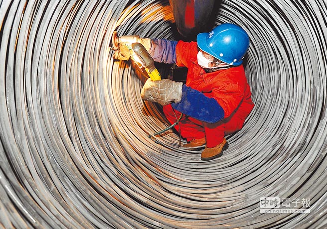 大陸工人檢查修磨合金鋼線材表面。（CFP）