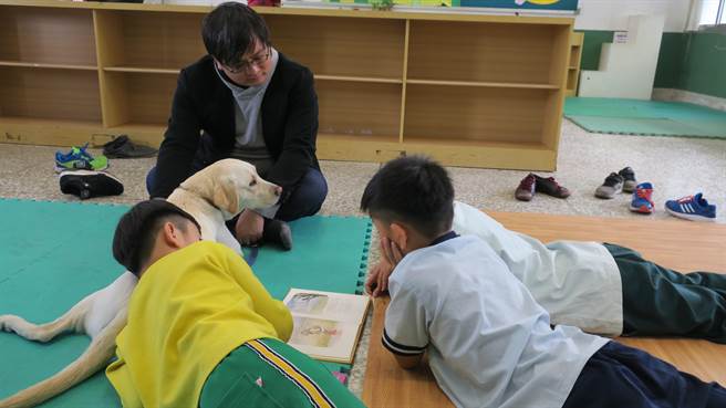 芬園鄉文德國小李秉軒老師每周五會帶著台灣導盲犬協會出借的狗兒到大村國小，陪伴孩子們閱讀。（謝瓊雲攝）