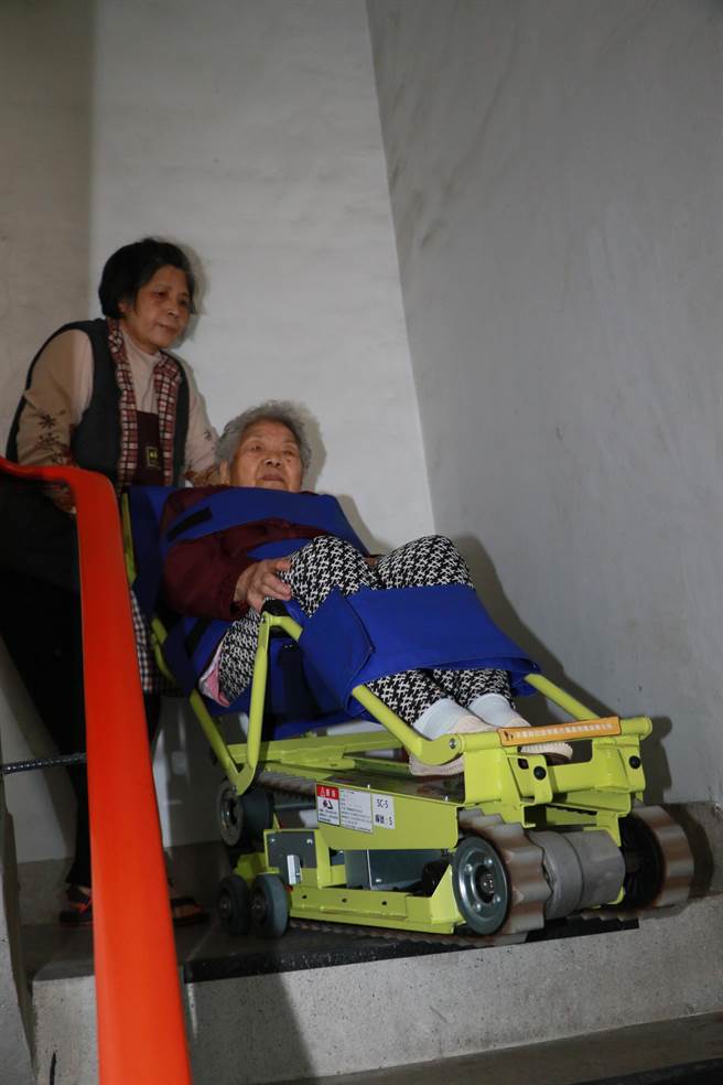 邱芹珍利用爬梯機協助婆婆上下樓梯。（葉書宏攝）