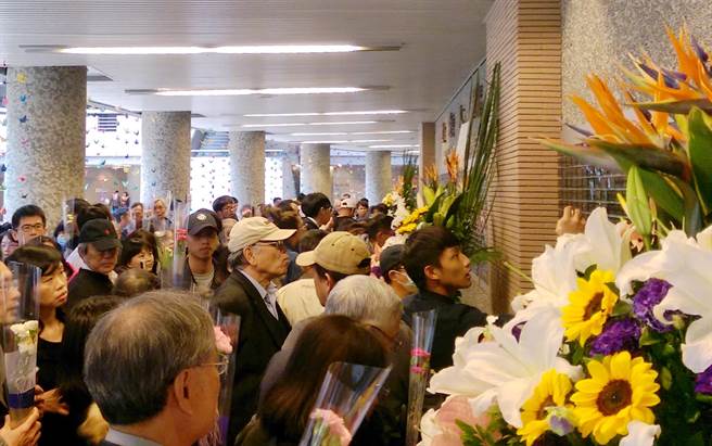 家属在遗爱人间纪念碑前献花，缅怀先人。（甘嘉雯摄）