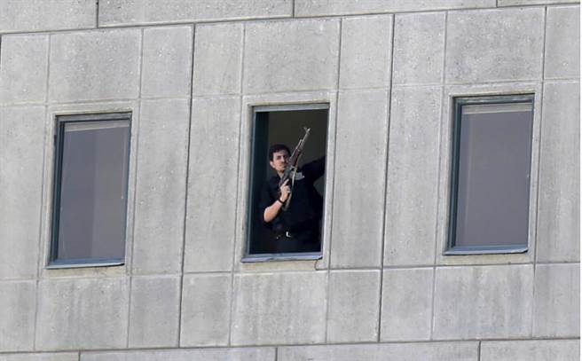 一名武裝男子7日站在伊朗德黑蘭國會建築的窗口，IS已出面承認發動攻擊。（圖/美聯社）