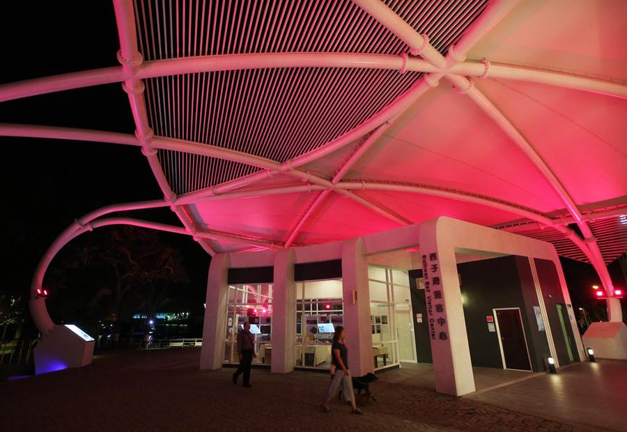 西子灣遊客中心正式啟用，橢圓美學建築外觀採用鋼結構與薄膜屋頂等綠建築設計，傍晚呈現多彩燈光變幻，吸引民眾參觀。（王錦河攝）
