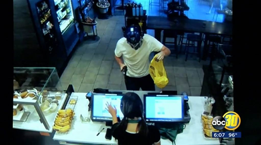 監視錄影畫面看到，一名持械男子在收銀檯前搶劫。(abc7news報導截圖)