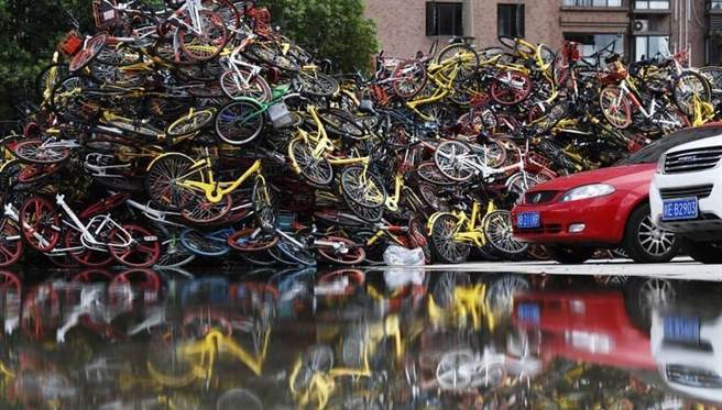 在上海居民樓附近空地上堆放的共享單車，已成為許多市民眼中的日常都市景觀。（圖／中新網）