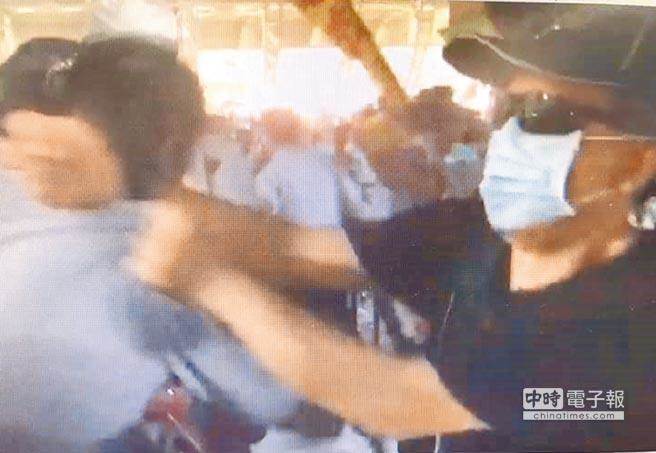 網友在世大運開幕式場外目擊，當晚毆打劉姓巡佐的，除被逮的顏才仁，還有戴口罩的黑衣男（右）也揮拳。警方證實該男涉案，積極追查中。（摘自臉書）