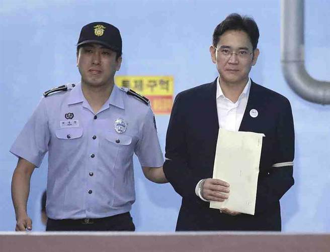 李在鎔在8月25日法院宣布判決後，在警衛護送下離開。(美聯社)
