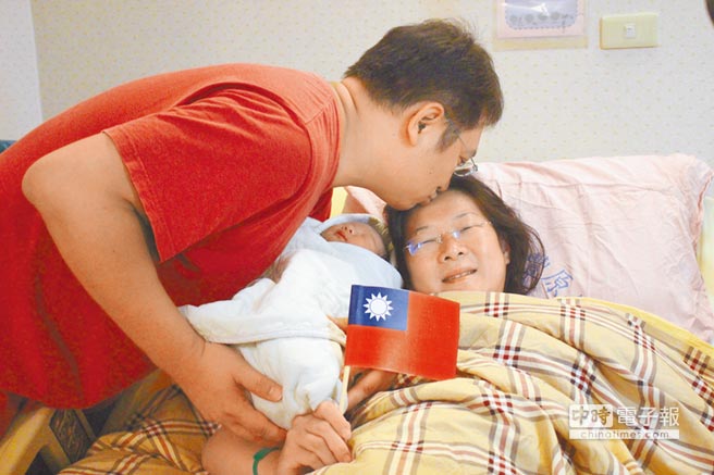兒子提早在國慶日報到，爸爸吳松融親吻辛苦的老婆，感謝她剖腹產下健康的寶寶。（陳淑娥攝）