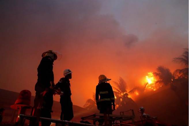消防員努力撲滅仰光皇宮飯店的火勢。(路透社)