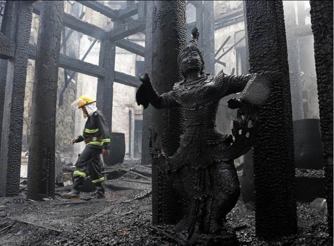 消防人員檢視遭火祝融的仰光皇宮飯店。(美聯社)
