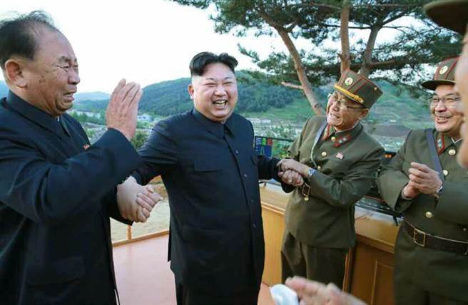 北韓最高領導人金正恩106年5月視察火星12型試射時，緊握北韓勞動黨中央委員會第一副部長李炳哲（左）的手，露出燦爛的笑容。（圖/北韓勞動新聞）