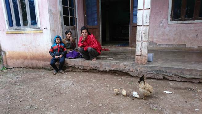 胡文發（左1）和父母親在家門前閒坐。（廖德修攝）