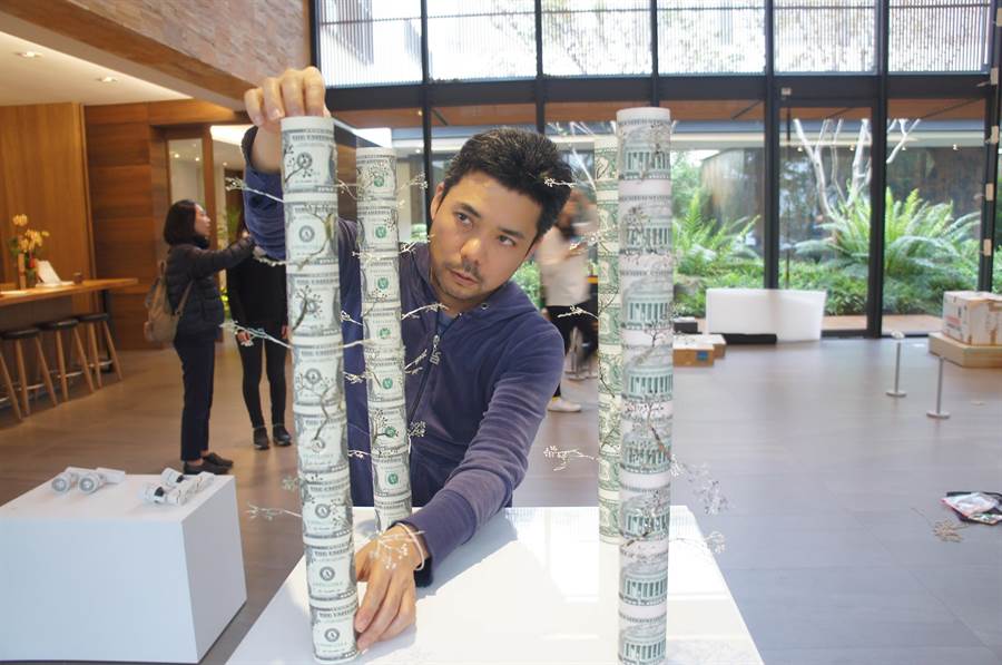 日本藝術家照屋勇賢善用廢棄消費紙製品創作，圖為他以紙鈔、報紙創作巨塔。（林欣儀攝）