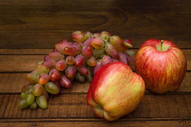 蘋果、葡萄與薑黃是三種能夠預防攝護腺癌症的重要食材。圖為蘋果與紅皮葡萄。（達志影像/shutterstock)