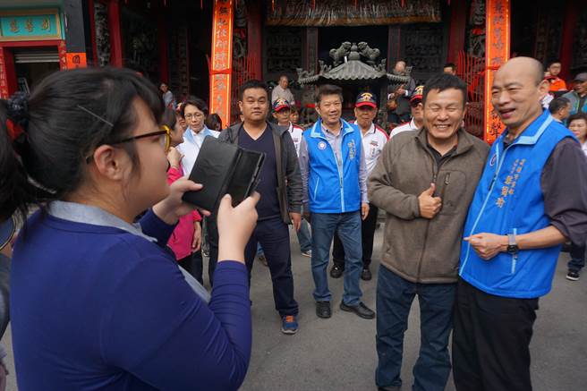 國民黨高雄市黨部主委韓國瑜（右）人氣旺，民眾搶著拍照。（柯宗緯攝）