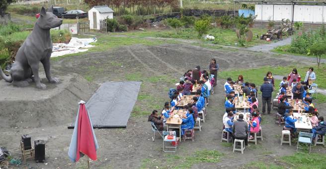 80名明禮國小小朋友在台灣土狗泥雕下方進行陶藝創作。（鐘武達攝）