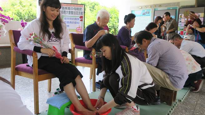 繁星上台大中文系的陳芊羽(右)，為母親羅丹妮洗腳，讓媽媽欣喜感動。（謝瓊雲攝）