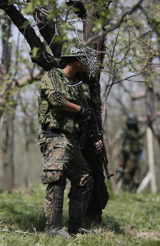一名印度士兵正在與武裝份子進行叢林槍戰。(圖/美聯社)
